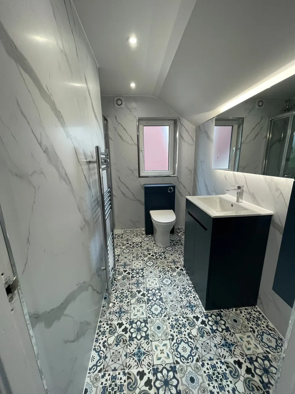 Navy bathroom furniture above patterned flooring
