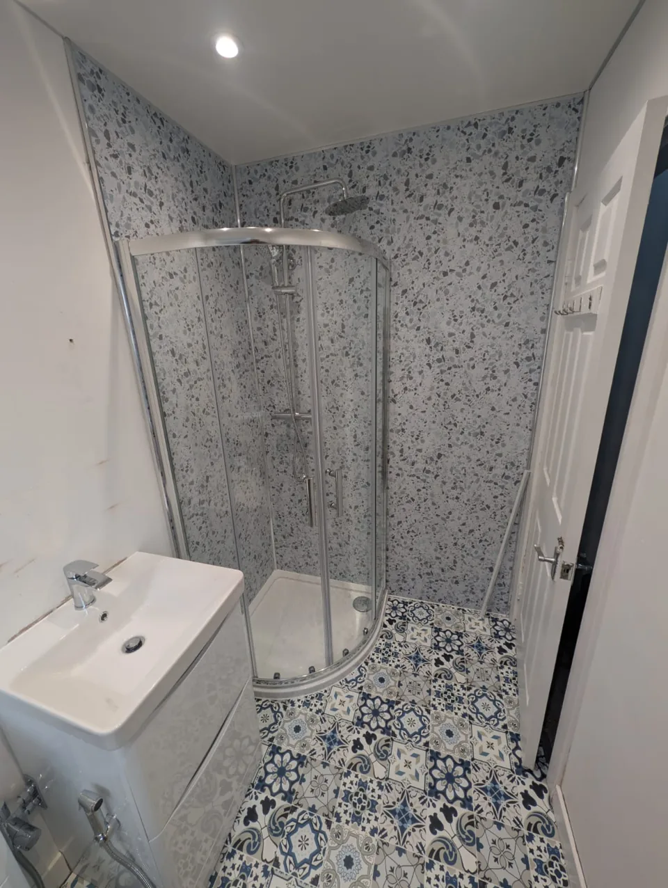 Curved shower enclosure with patterned walls and floor